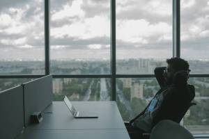 Man sits at desk in front of laptop contemplating