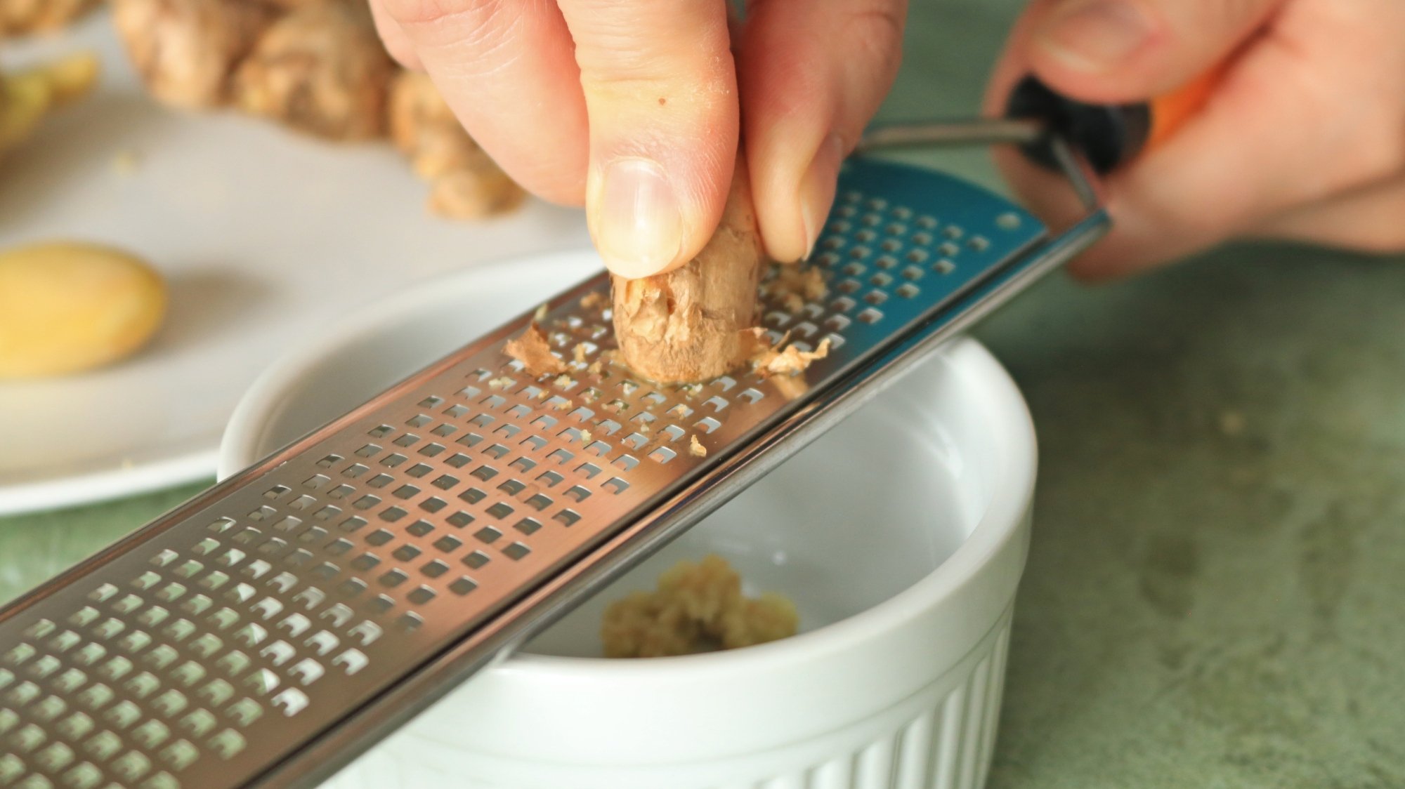 Hand grating ginger root on a microplane.
