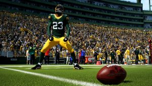 a player for the Green Bay Packers celebrates in the endzone with a football resting in the foreground, in a scene from Madden NFL 24
