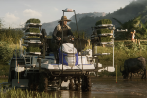 A screenshot of the Farming Simulator 25 cinematic trailer showing a farmer on a piece of farming equipment